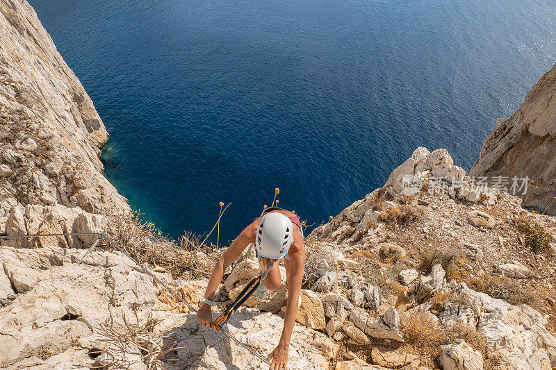 费拉塔岛(Via Ferrata)上的攀登者，年轻的妇女们在攀登海面上的岩石